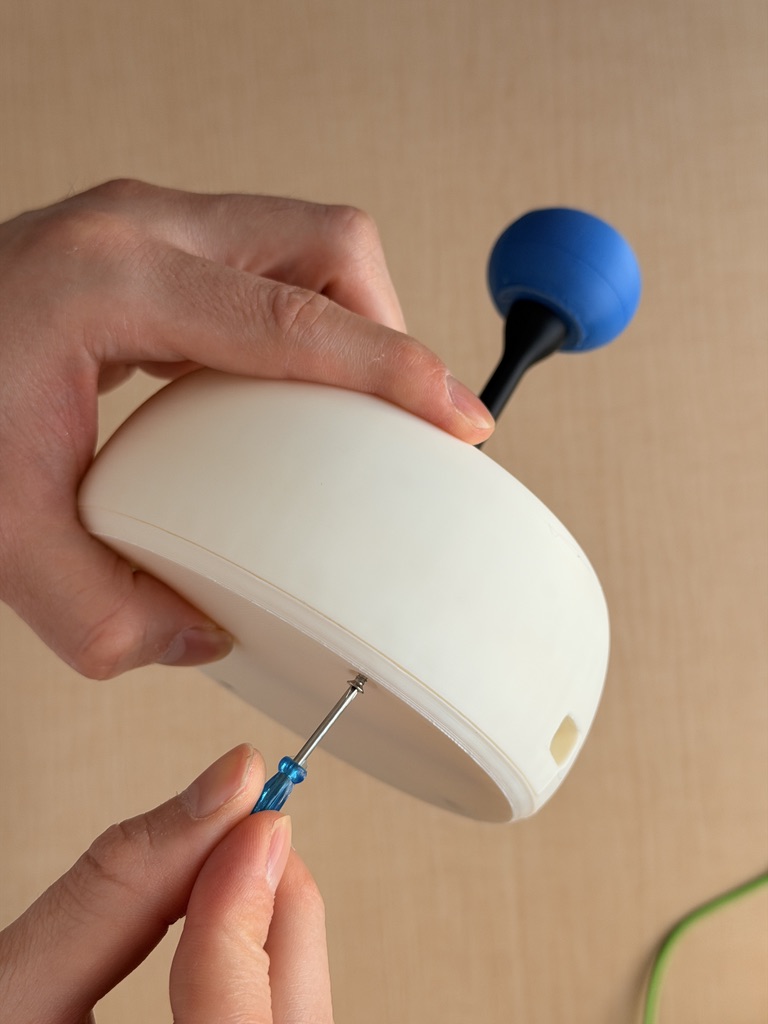 Hands fastening the white printed Rshifter shell with a screwdriver